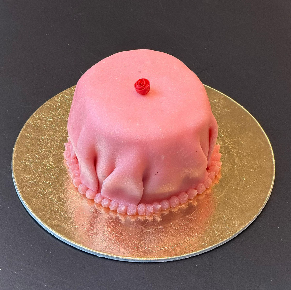 Princess mini cake covered in homemade marzipan with diplomat cream and raspberry coulis.
