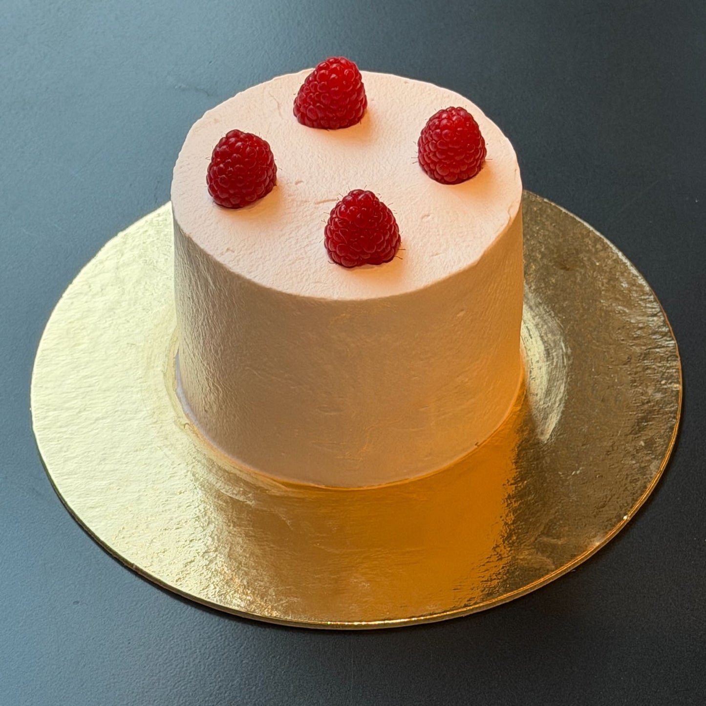 Raspberry rose mini cake with rose whipped cream, raspberry coulis, and fresh raspberries.